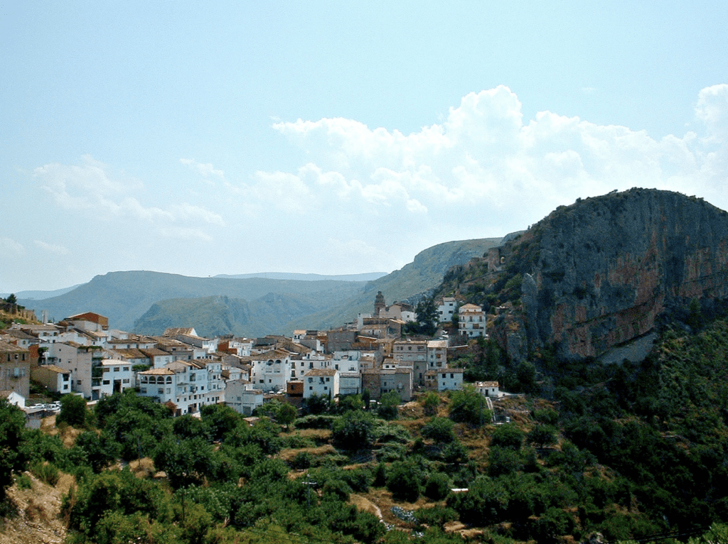 Vue sur le village de Chulilla en Espagne. Des maisons en haut d'une montagne, de la forêt, un ciel bleu avec peu de nuage