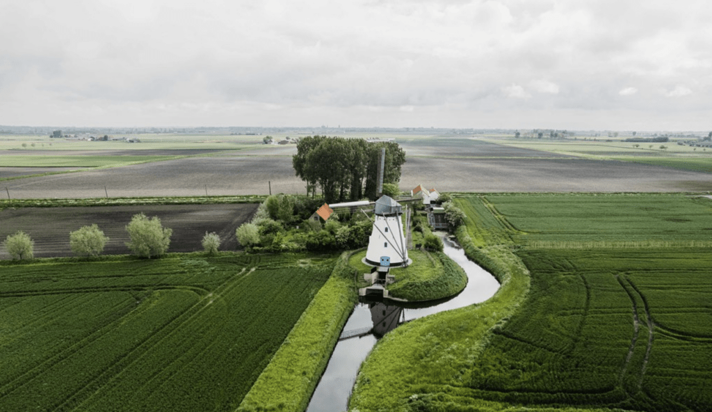 vue aérienne de champs et d'un moulin blanc